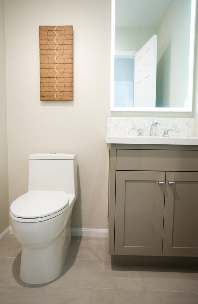 Inredning av ett modernt litet toalett, med skåp i shakerstil, en toalettstol med hel cisternkåpa, vit kakel, mosaik, vita väggar, klinkergolv i keramik, ett nedsänkt handfat, bänkskiva i kvarts och grått golv