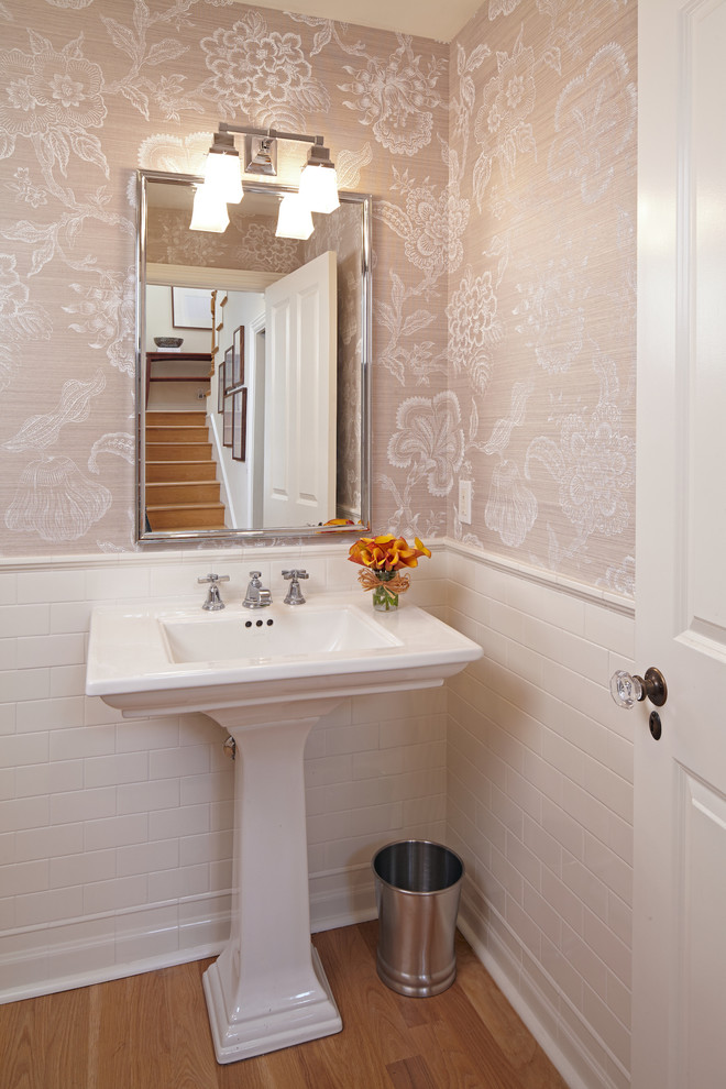 Small contemporary cloakroom in Los Angeles with white tiles, ceramic tiles, multi-coloured walls, medium hardwood flooring and a pedestal sink.