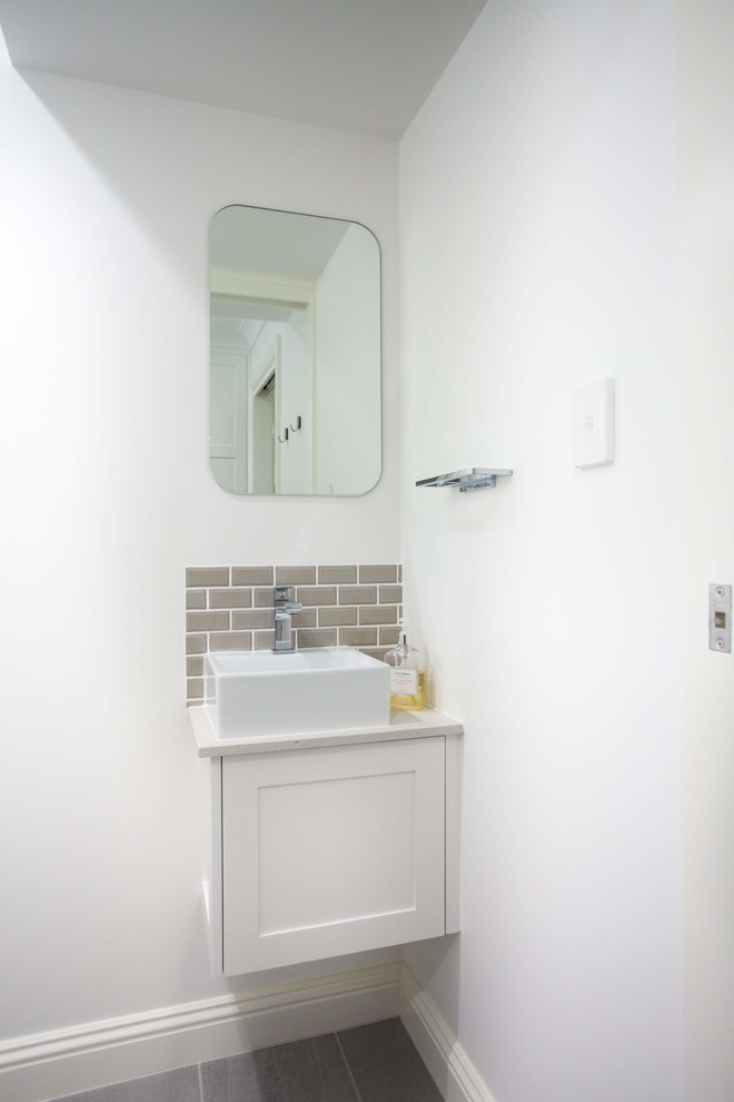 Inspiration for a small classic cloakroom in Brisbane with shaker cabinets, white cabinets, a one-piece toilet, brown tiles, ceramic tiles, white walls, porcelain flooring, a vessel sink, engineered stone worktops, grey floors and white worktops.