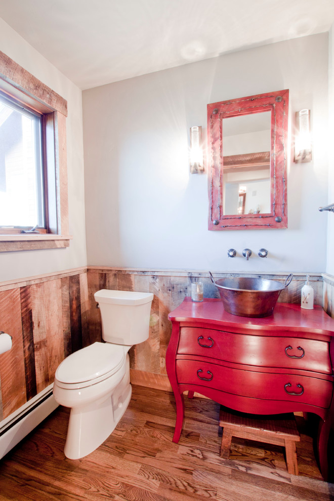Foto di un bagno di servizio stile rurale con lavabo a bacinella, consolle stile comò, ante rosse, top in legno, pareti grigie e pavimento in legno massello medio