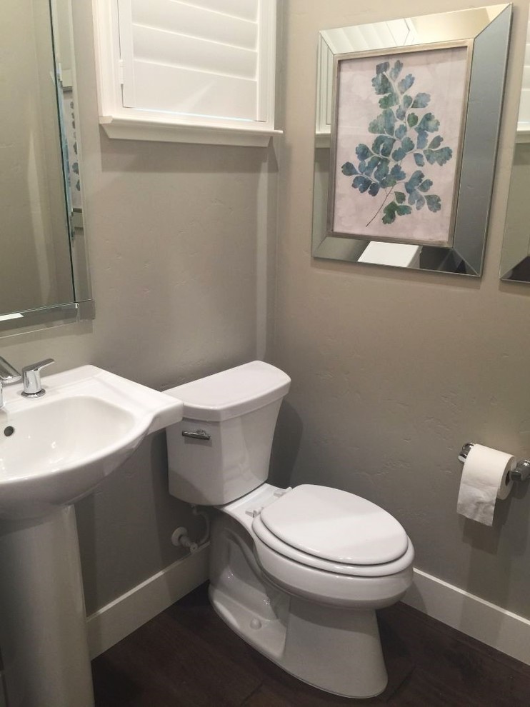 Immagine di un bagno di servizio design di medie dimensioni con WC a due pezzi, pareti grigie, pavimento in vinile e lavabo a colonna