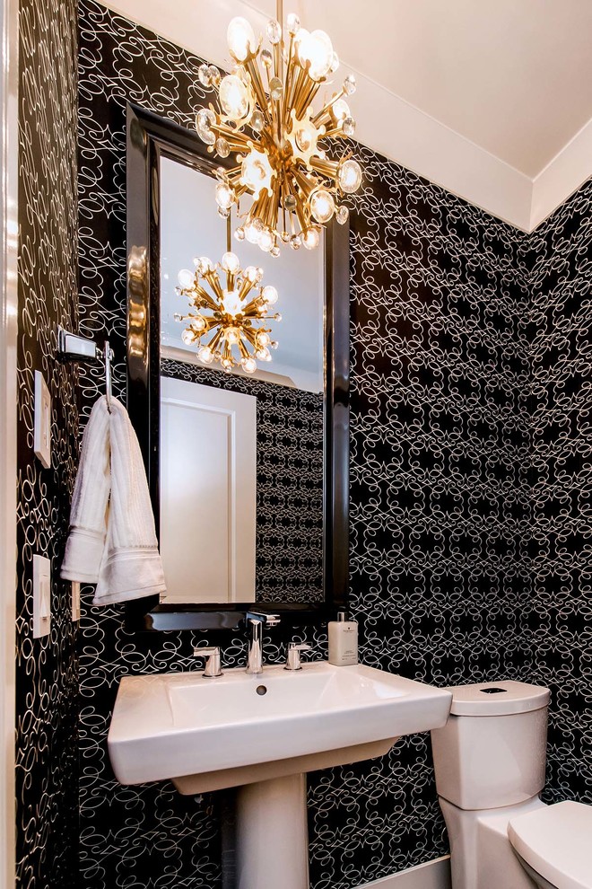 На фото: туалет в стиле неоклассика (современная классика) с раковиной с пьедесталом, черными стенами и раздельным унитазом с