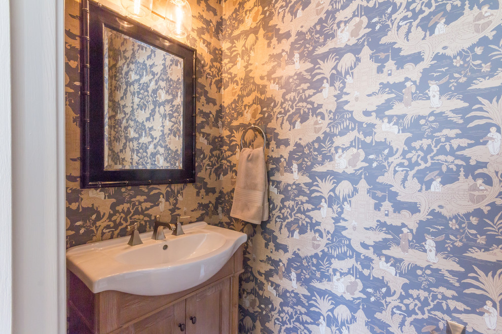 Foto på ett litet orientaliskt toalett, med möbel-liknande, skåp i slitet trä, en toalettstol med hel cisternkåpa, blå väggar, mellanmörkt trägolv och ett integrerad handfat