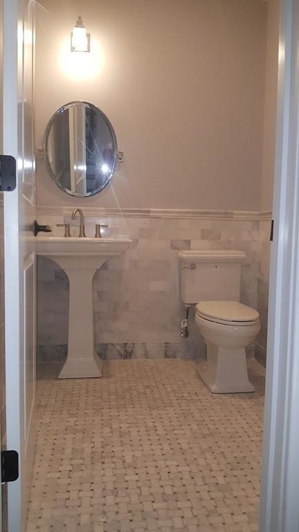 This is an example of a small contemporary cloakroom in Boston with a two-piece toilet, multi-coloured tiles, marble tiles, grey walls, marble flooring, a pedestal sink and multi-coloured floors.