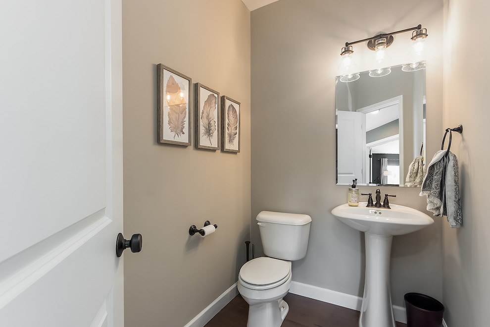 Design ideas for a large modern cloakroom in Columbus with a two-piece toilet, grey walls, medium hardwood flooring and a pedestal sink.