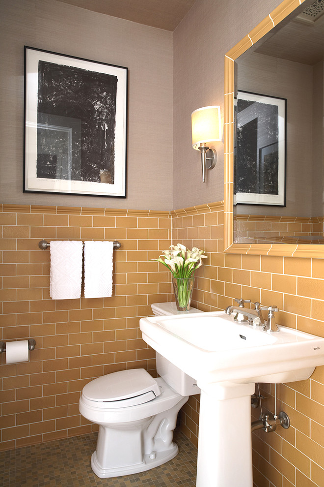 Inredning av ett amerikanskt toalett, med ett piedestal handfat, orange kakel, tunnelbanekakel, grå väggar, klinkergolv i keramik och en toalettstol med separat cisternkåpa