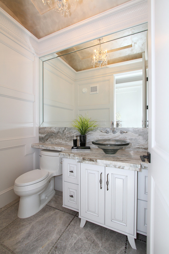 Powder room - mid-sized transitional porcelain tile powder room idea in Vancouver with raised-panel cabinets, white cabinets, a two-piece toilet, white walls, a vessel sink and granite countertops