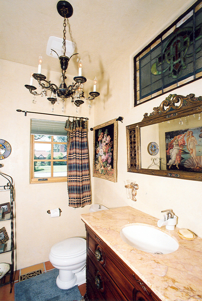 Exemple d'un WC et toilettes méditerranéen en bois brun avec un placard en trompe-l'oeil, un plan de toilette en marbre, WC à poser et un carrelage orange.