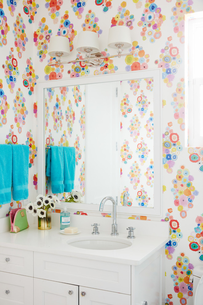 Immagine di un bagno di servizio minimal con ante con riquadro incassato, ante bianche, pareti multicolore e lavabo sottopiano