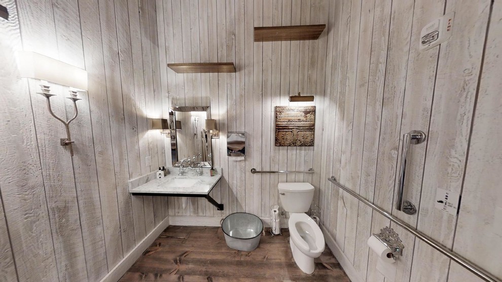 Пример оригинального дизайна: туалет среднего размера в стиле кантри с паркетным полом среднего тона, мраморной столешницей и коричневым полом