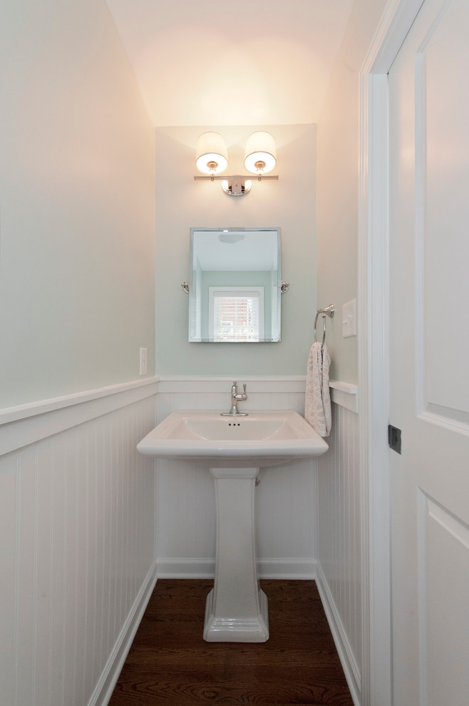Cette photo montre un WC et toilettes chic avec un mur bleu, un sol en bois brun et un lavabo de ferme.