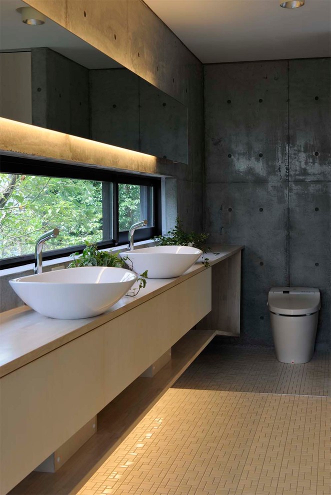 Réalisation d'un WC et toilettes design avec un mur gris, une vasque et un sol beige.