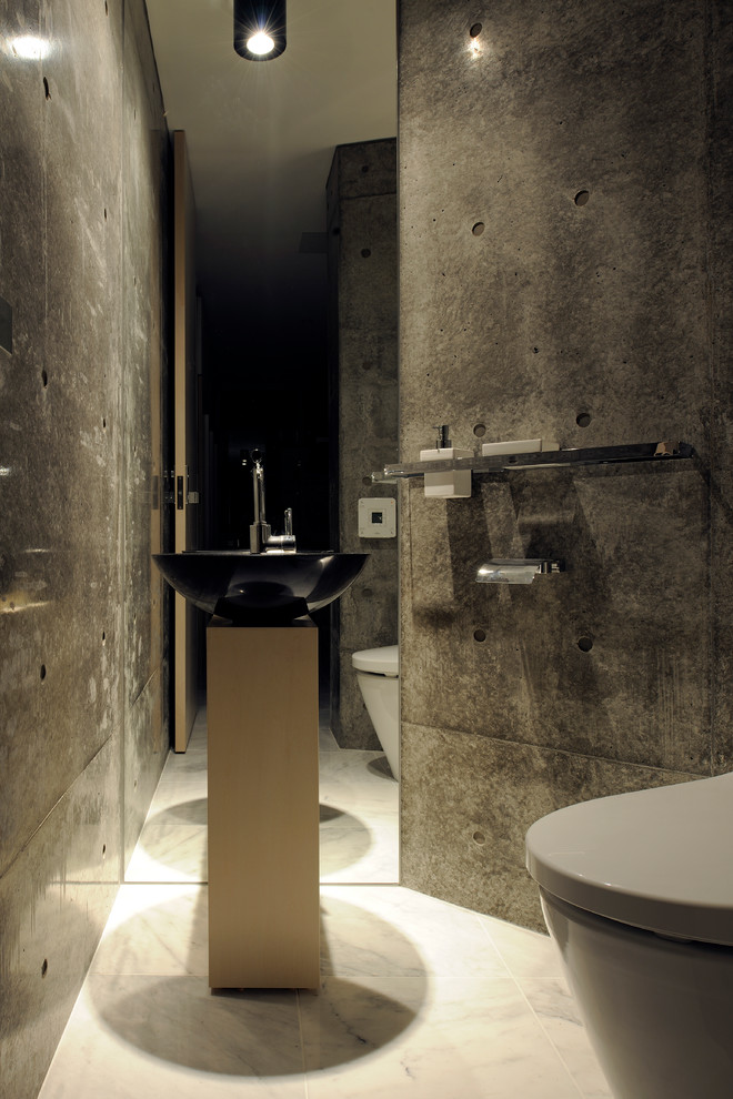 Idées déco pour un WC et toilettes contemporain avec un mur gris et une vasque.
