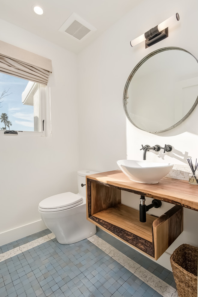 Inspiration for a contemporary cloakroom in Orange County with open cabinets, medium wood cabinets, a one-piece toilet, white walls, a vessel sink and multi-coloured floors.