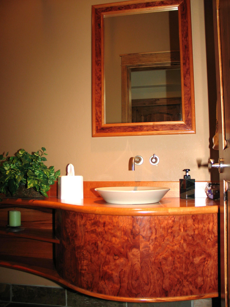 Esempio di un bagno di servizio design di medie dimensioni con ante lisce, ante in legno scuro, pavimento in ardesia, lavabo a bacinella e top in legno