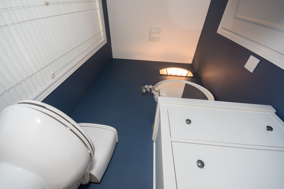 Cette photo montre un WC et toilettes tendance de taille moyenne avec un placard à porte shaker, des portes de placard blanches, WC séparés, un mur bleu, un sol en carrelage de porcelaine, un lavabo intégré et un sol beige.