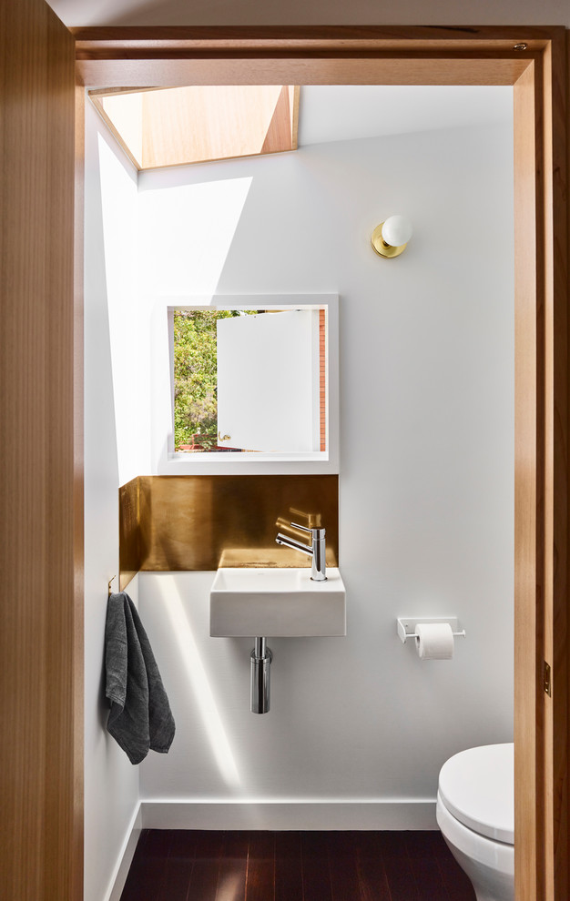 Immagine di un piccolo bagno di servizio design con ante in legno chiaro, parquet scuro e pavimento nero