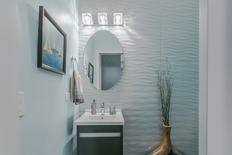 Idée de décoration pour un WC et toilettes design de taille moyenne avec un carrelage blanc, des carreaux de céramique, un mur bleu et un lavabo encastré.