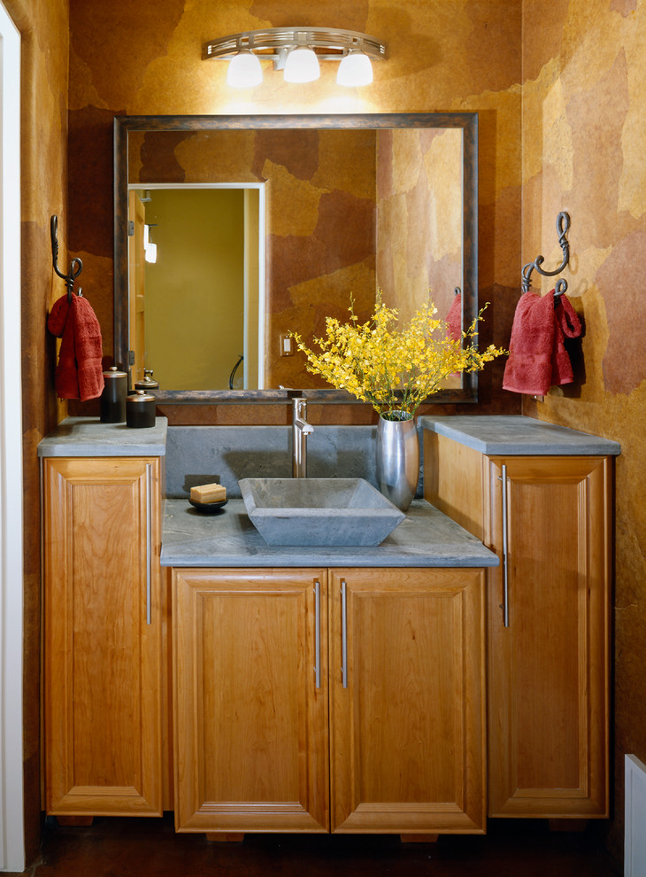 Idée de décoration pour un WC et toilettes design en bois brun de taille moyenne avec un placard avec porte à panneau encastré, un mur marron, une vasque, un plan de toilette en béton et un plan de toilette gris.