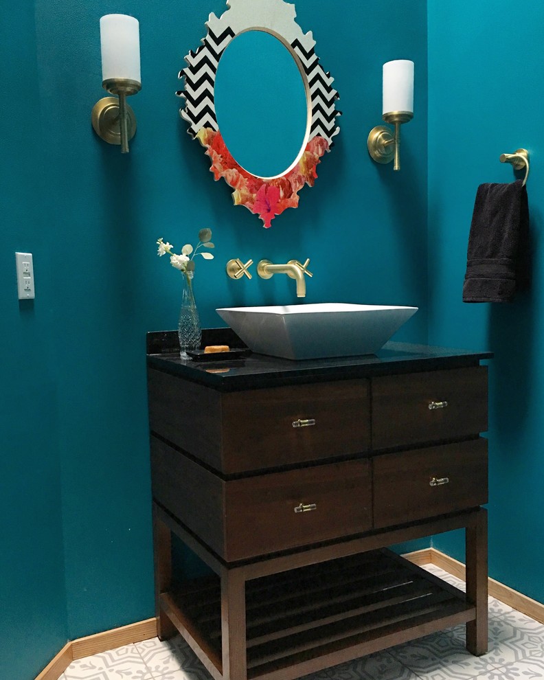 Design ideas for a medium sized modern cloakroom in Raleigh with freestanding cabinets, medium wood cabinets, a two-piece toilet, grey tiles, blue walls, a vessel sink, granite worktops and cement flooring.