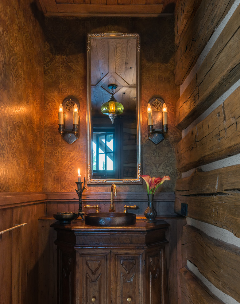 Urige Gästetoilette mit verzierten Schränken, dunklen Holzschränken, brauner Wandfarbe, Aufsatzwaschbecken, Waschtisch aus Holz und brauner Waschtischplatte in Sonstige