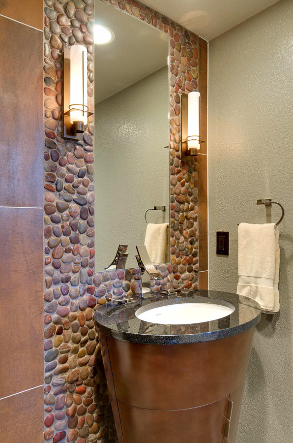 Cette image montre un petit WC et toilettes traditionnel en bois foncé avec un lavabo encastré, un placard à porte plane, un plan de toilette en quartz modifié, WC à poser, un carrelage multicolore, une plaque de galets et un mur gris.