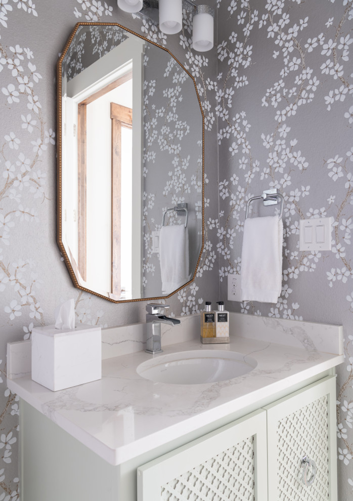 Ispirazione per un bagno di servizio classico di medie dimensioni con consolle stile comò, ante bianche, pareti multicolore, lavabo sottopiano, top in marmo e top bianco