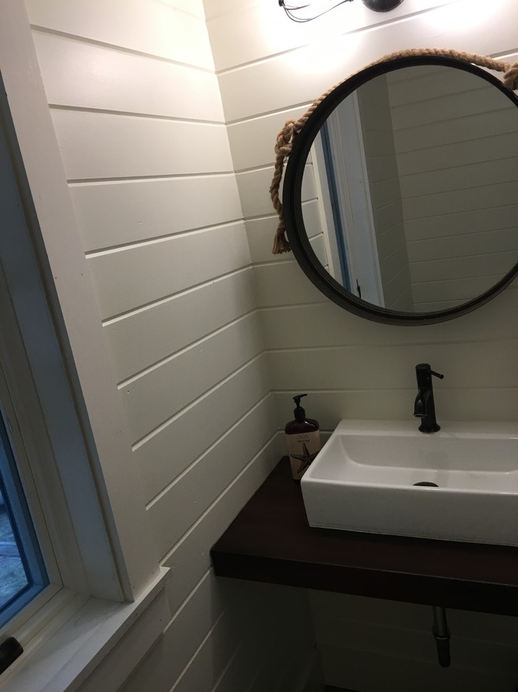 На фото: маленький туалет в морском стиле с открытыми фасадами, раздельным унитазом, белыми стенами, светлым паркетным полом, настольной раковиной и столешницей из дерева для на участке и в саду