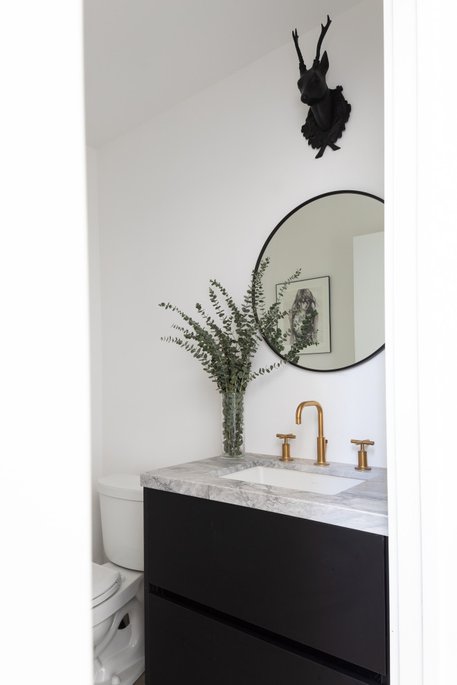 This is an example of a small modern cloakroom in Los Angeles with flat-panel cabinets, black cabinets, a one-piece toilet, white walls, medium hardwood flooring, a built-in sink, engineered stone worktops, brown floors, grey worktops and a floating vanity unit.