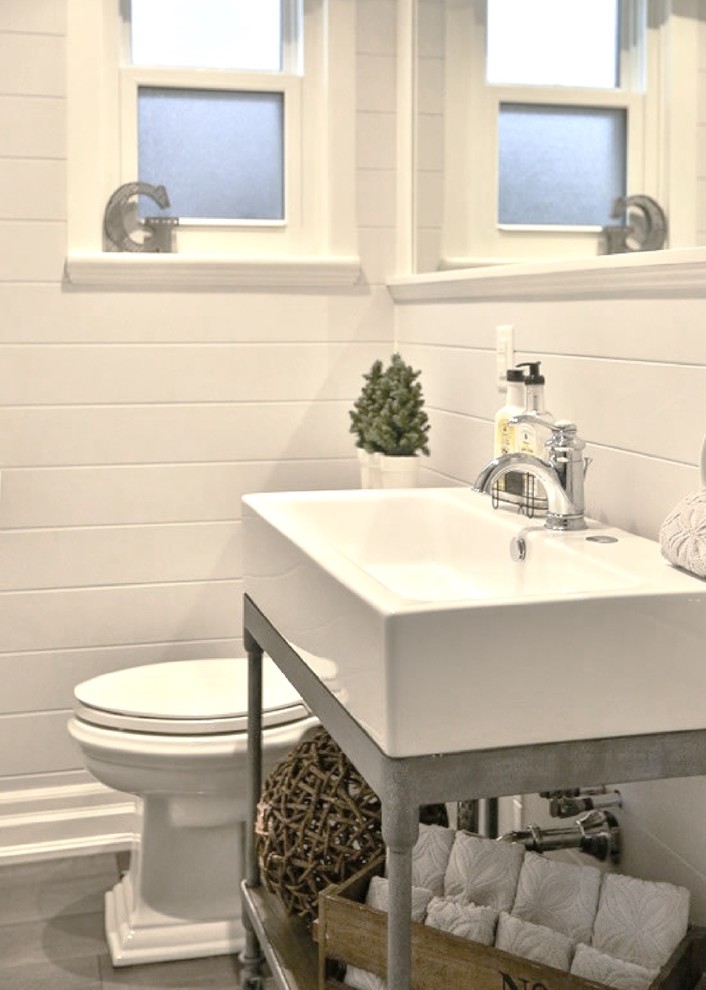 Idéer för små vintage toaletter, med en toalettstol med separat cisternkåpa, grå väggar, mörkt trägolv, ett avlångt handfat och brunt golv