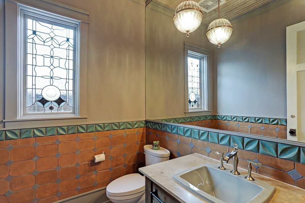 Inspiration for a mid-sized contemporary brown tile, multicolored tile and terra-cotta tile powder room remodel in Houston with a two-piece toilet, beige walls, a drop-in sink, granite countertops and beige countertops