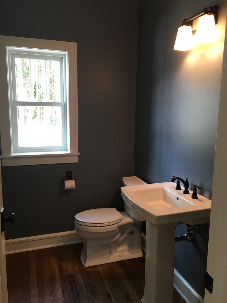 Mittelgroße Rustikale Gästetoilette mit Wandtoilette mit Spülkasten, blauer Wandfarbe, dunklem Holzboden und Sockelwaschbecken in Milwaukee