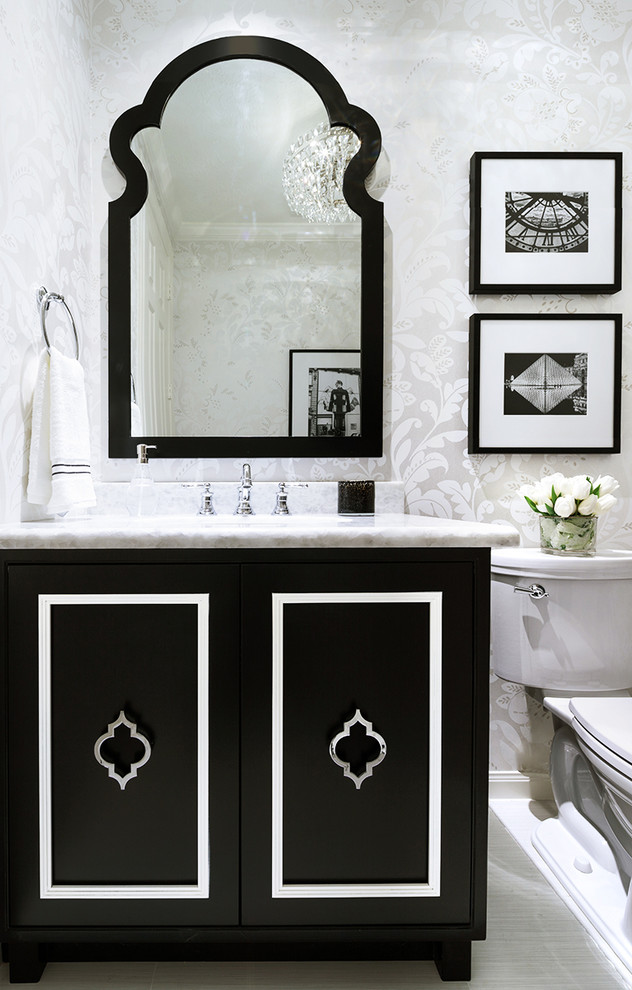 Klassisk inredning av ett litet toalett, med möbel-liknande, svarta skåp, en toalettstol med hel cisternkåpa, klinkergolv i porslin, ett nedsänkt handfat, bänkskiva i kvartsit, vitt golv och vita väggar