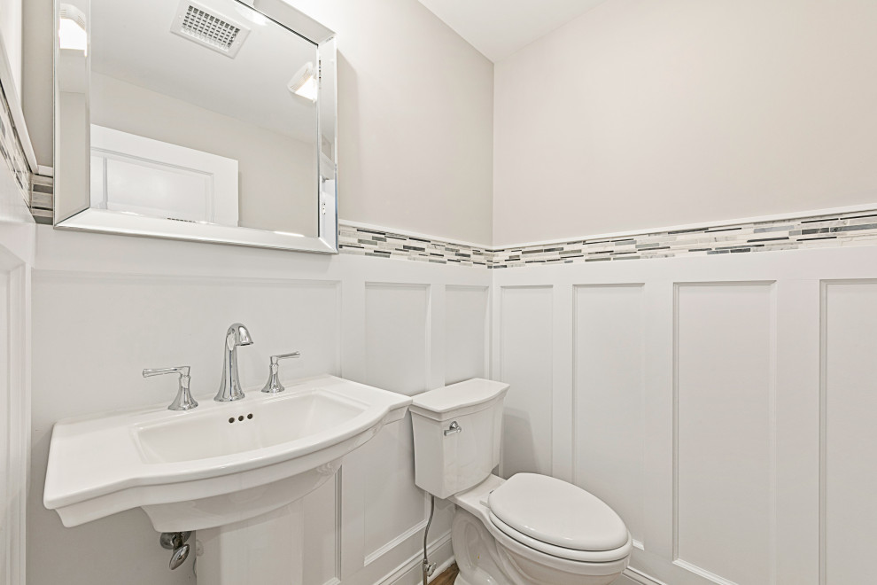 Immagine di un bagno di servizio stile marino con WC monopezzo, pareti grigie, lavabo a colonna e pannellatura