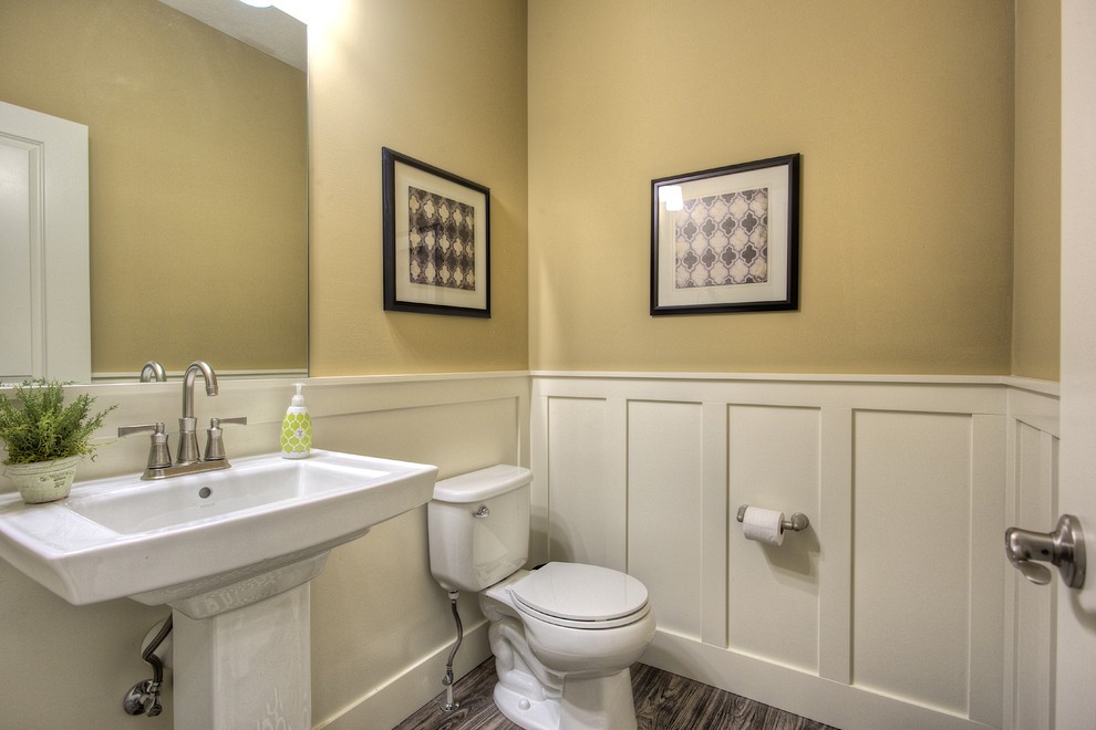 На фото: туалет в классическом стиле с раковиной с пьедесталом, раздельным унитазом, бежевыми стенами и полом из линолеума с