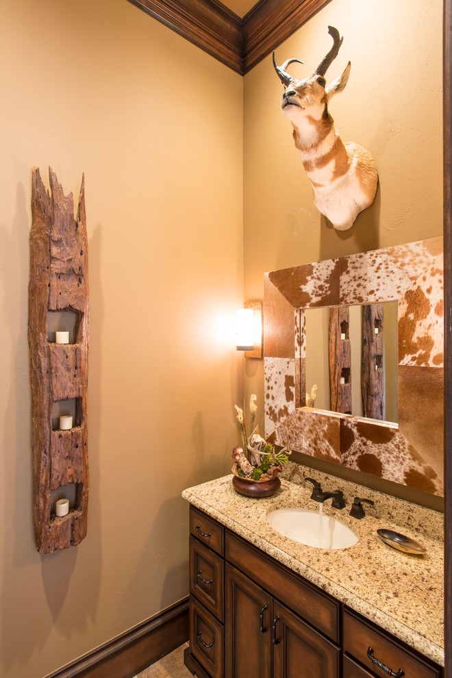 Immagine di un bagno di servizio rustico di medie dimensioni con consolle stile comò, ante in legno bruno, pareti beige, lavabo sottopiano e top in granito