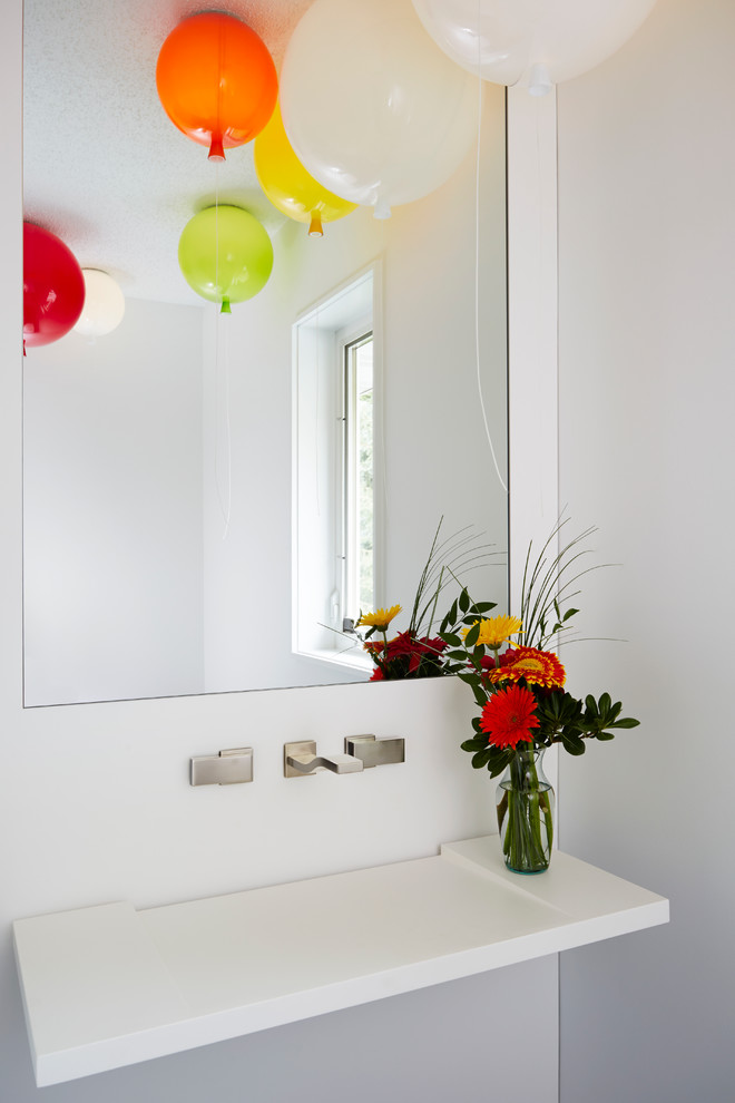 Imagen de aseo actual con lavabo suspendido y paredes blancas