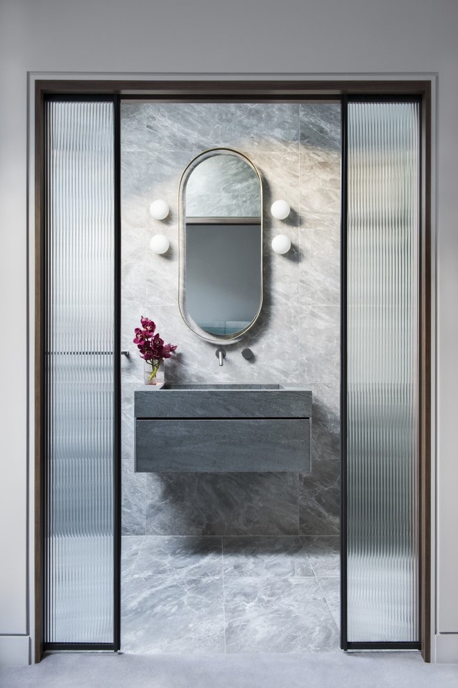Moderne Gästetoilette mit flächenbündigen Schrankfronten, grauen Schränken, grauen Fliesen, grauer Wandfarbe, integriertem Waschbecken, grauem Boden und grauer Waschtischplatte in Sydney