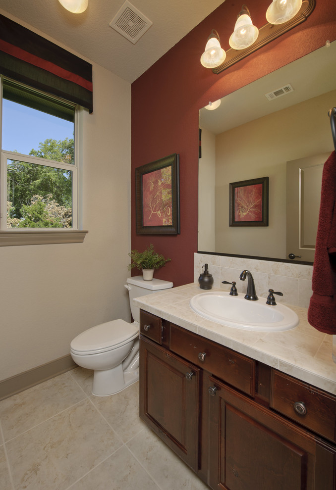 Medium sized classic cloakroom in Houston with raised-panel cabinets, a two-piece toilet, beige tiles, limestone tiles, beige walls, limestone flooring, a submerged sink, limestone worktops, beige floors and beige worktops.
