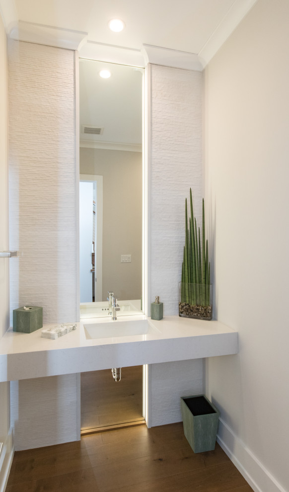 Mittelgroße Moderne Gästetoilette mit weißen Fliesen, grauer Wandfarbe, integriertem Waschbecken, braunem Boden, weißer Waschtischplatte und schwebendem Waschtisch in Sonstige