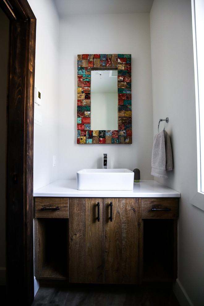 Kleine Country Gästetoilette mit flächenbündigen Schrankfronten, dunklen Holzschränken, weißer Wandfarbe, Porzellan-Bodenfliesen, Aufsatzwaschbecken und Laminat-Waschtisch in Montreal