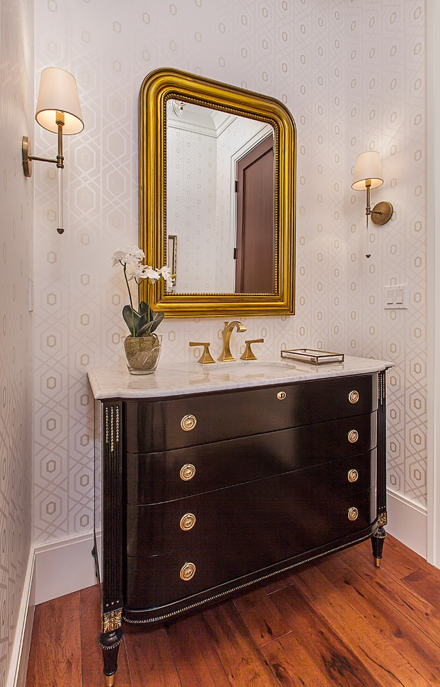 Powder room - mid-sized traditional dark wood floor and brown floor powder room idea in Detroit with furniture-like cabinets, black cabinets, a one-piece toilet, white walls, an undermount sink, marble countertops and white countertops