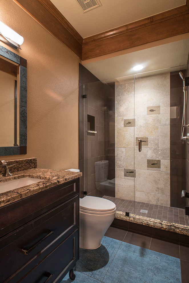 Design ideas for a medium sized classic cloakroom in Denver with dark wood cabinets, a two-piece toilet, brown tiles, porcelain tiles, beige walls, porcelain flooring, a submerged sink, granite worktops and freestanding cabinets.