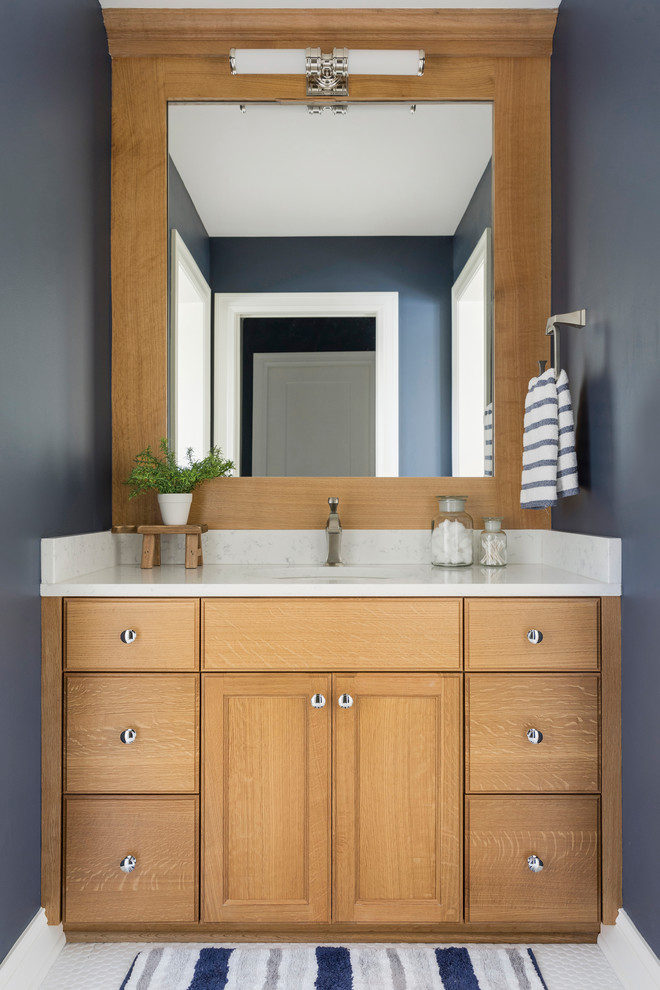 Foto di un bagno di servizio stile marinaro con lavabo sottopiano, top bianco e ante in legno chiaro