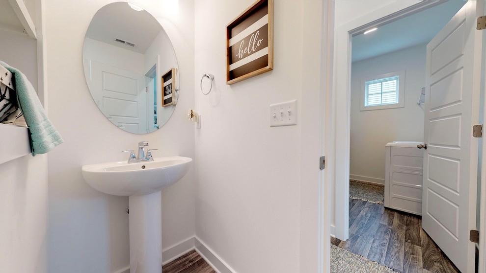 Cette image montre un petit WC et toilettes craftsman avec WC à poser, un mur gris, un sol en linoléum, un lavabo de ferme et un sol gris.