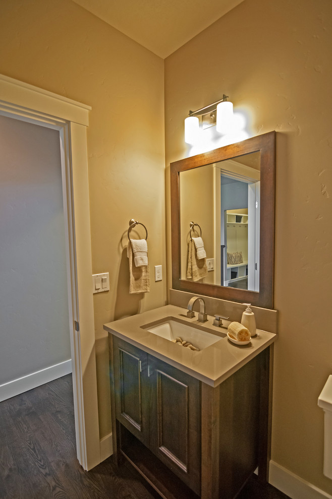 Inspiration pour un petit WC et toilettes craftsman en bois foncé avec un lavabo encastré, un placard en trompe-l'oeil, un plan de toilette en quartz, WC à poser et un mur gris.