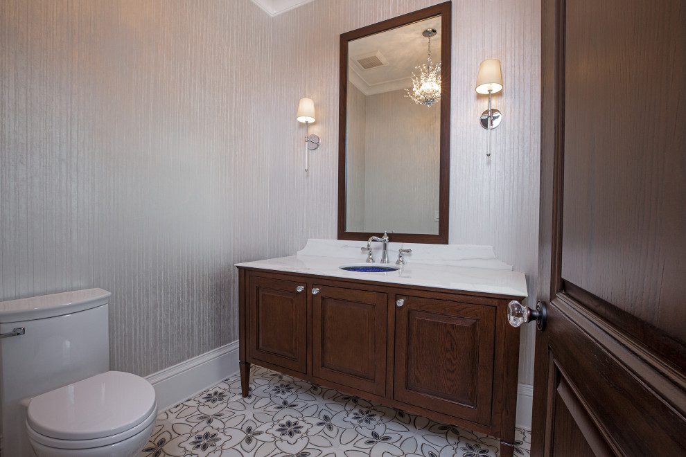 Inspiration for a large traditional cloakroom in Miami with raised-panel cabinets, dark wood cabinets, a two-piece toilet, grey tiles, grey walls, porcelain flooring, a submerged sink, marble worktops, multi-coloured floors and white worktops.