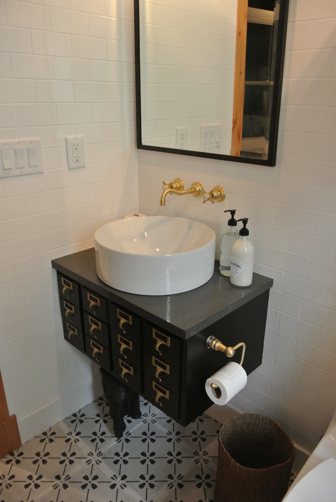 デンバーにある高級な中くらいなエクレクティックスタイルのおしゃれなトイレ・洗面所 (黒いキャビネット、一体型トイレ	、白いタイル、セラミックタイル、白い壁、セラミックタイルの床、ベッセル式洗面器、クオーツストーンの洗面台) の写真