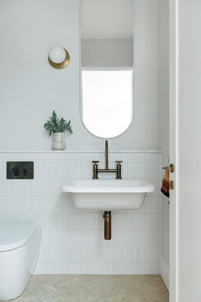 Inredning av ett lantligt mellanstort toalett, med en toalettstol med hel cisternkåpa, vit kakel, keramikplattor, grå väggar, klinkergolv i keramik och ett avlångt handfat