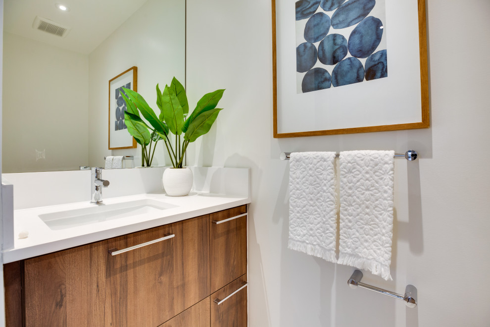 Medium sized modern cloakroom in DC Metro with flat-panel cabinets, dark wood cabinets, white walls, a submerged sink, engineered stone worktops, white worktops and a built in vanity unit.
